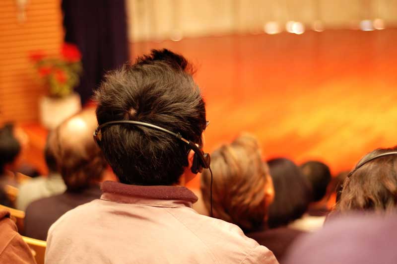 Man in auditiorium listening to headphones